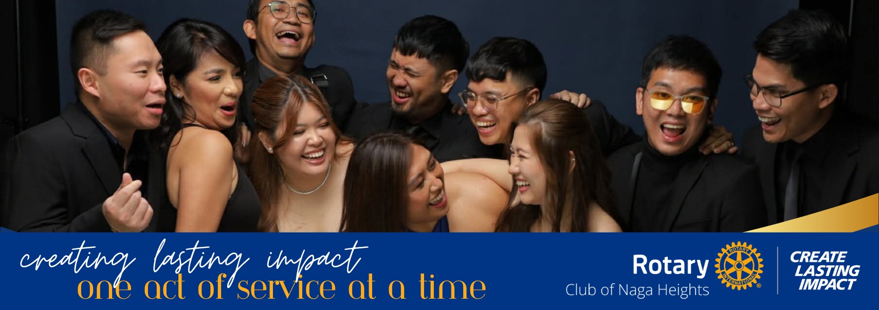 Rotary Club of Naga Heights members laughing together at a club gathering, with the club's Create Lasting Impact theme banner.